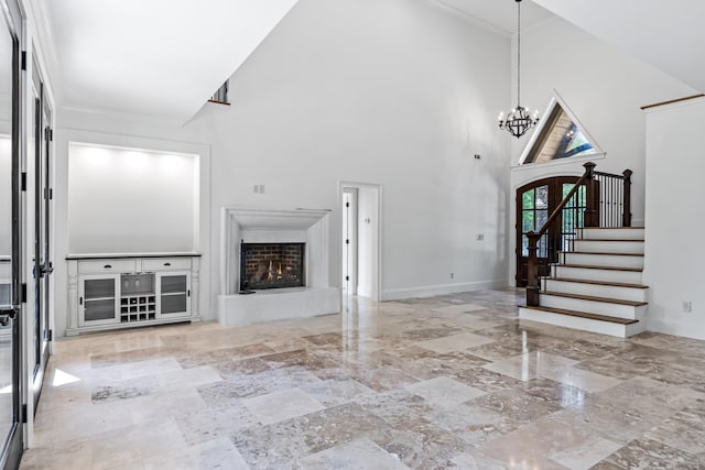 unfurnished living room with a notable chandelier and a towering ceiling