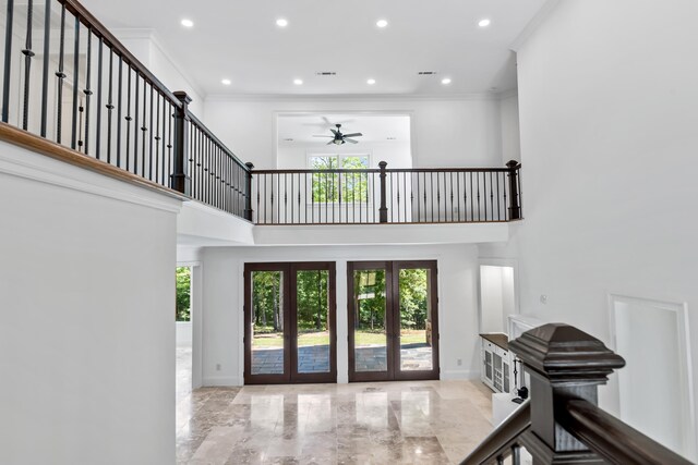 entrance foyer featuring french doors, ceiling fan, crown molding, and a high ceiling