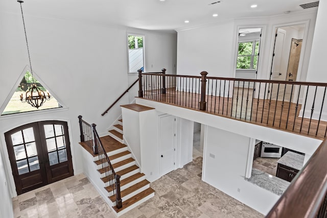 interior space featuring french doors, plenty of natural light, crown molding, and a notable chandelier