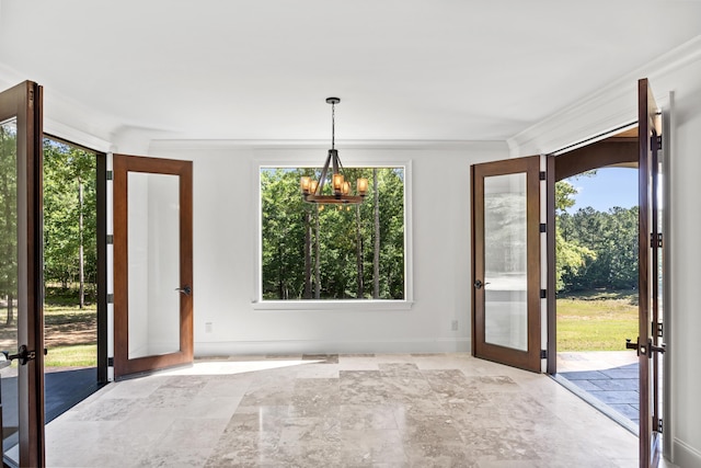 doorway with a notable chandelier, ornamental molding, and french doors