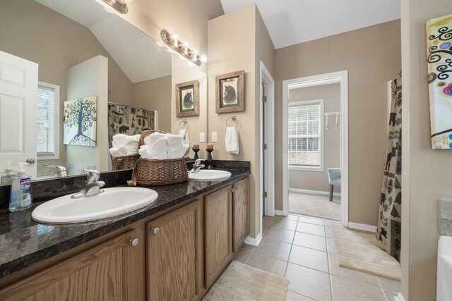 bathroom featuring vanity, vaulted ceiling, and tile patterned floors