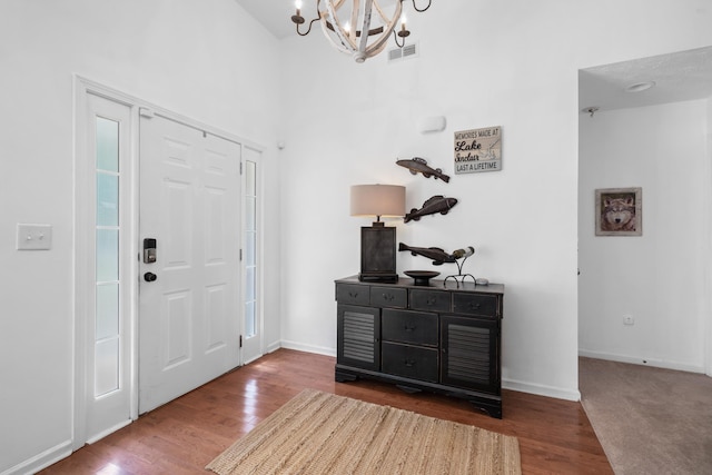 foyer entrance featuring hardwood / wood-style flooring and an inviting chandelier