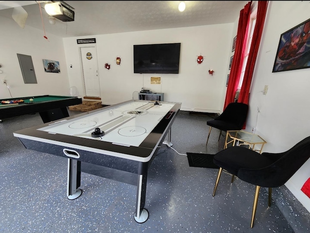 recreation room with electric panel and a textured ceiling