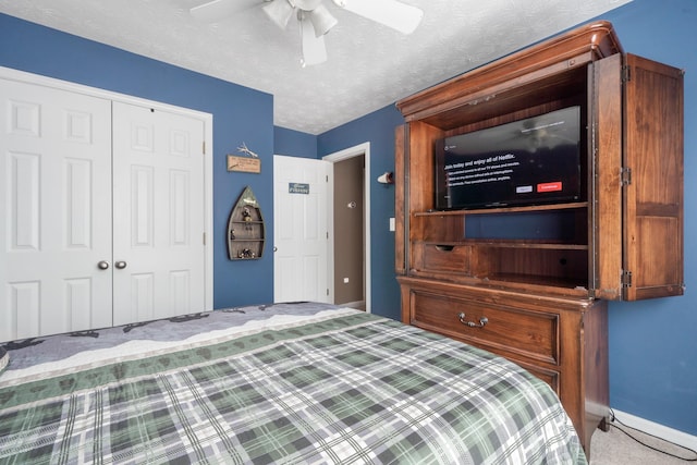 unfurnished bedroom featuring ceiling fan, carpet floors, a closet, and a textured ceiling