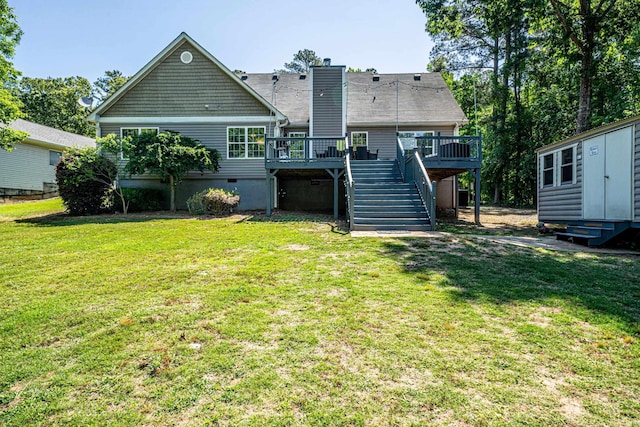 back of property featuring a wooden deck, a lawn, and a storage shed