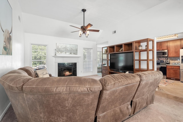 living room featuring high vaulted ceiling, light colored carpet, and ceiling fan