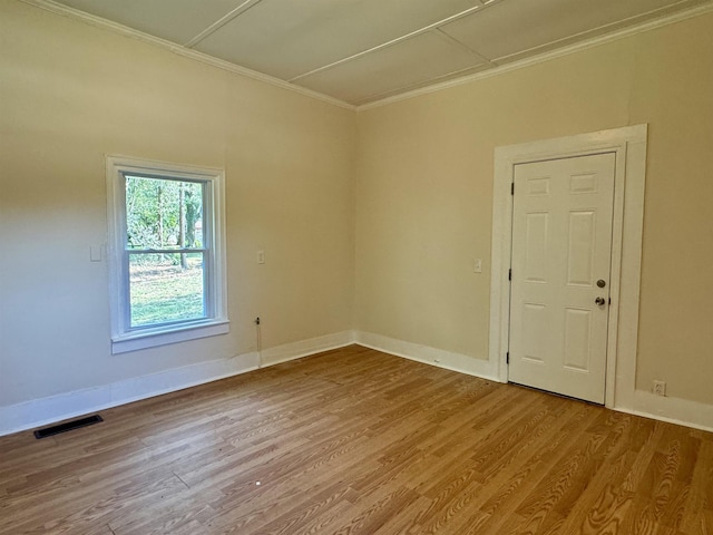 spare room featuring crown molding and hardwood / wood-style flooring