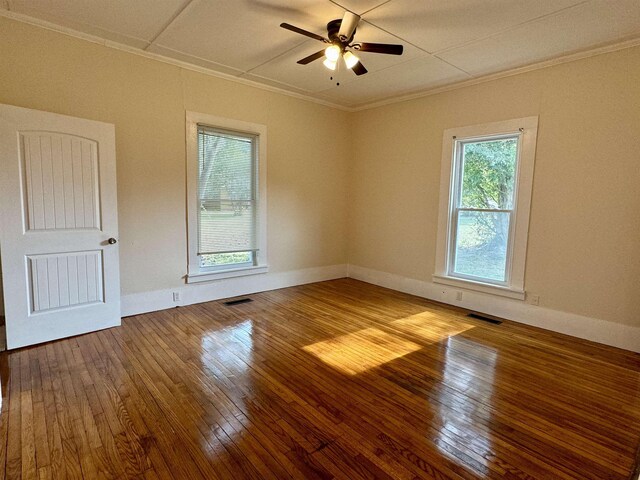 spare room featuring wood-type flooring, ceiling fan, and crown molding