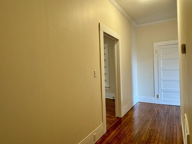 hallway featuring dark hardwood / wood-style flooring and crown molding