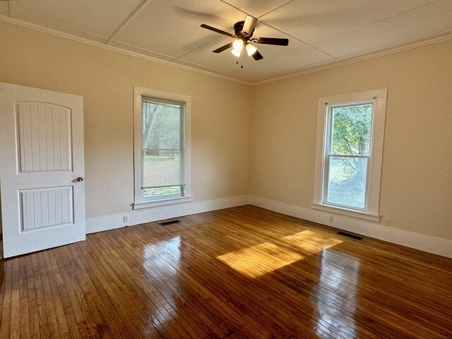 empty room with hardwood / wood-style flooring, ornamental molding, and ceiling fan