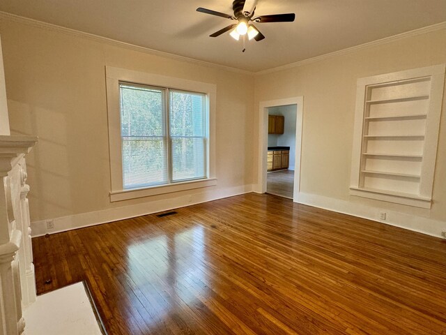 unfurnished living room with crown molding, ceiling fan, dark hardwood / wood-style flooring, and built in features