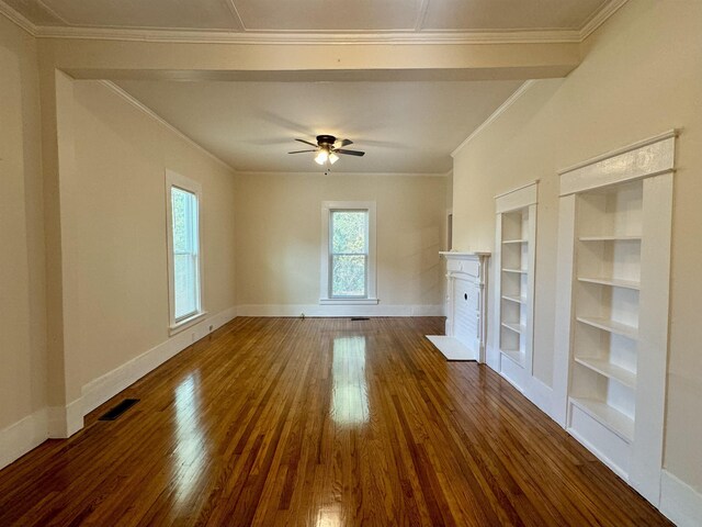 unfurnished living room featuring ornamental molding, dark wood-type flooring, ceiling fan, and built in shelves