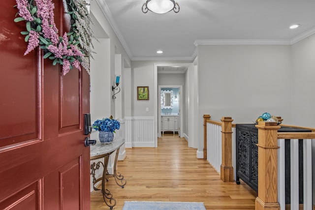 foyer entrance featuring ornamental molding, light wood finished floors, wainscoting, and recessed lighting