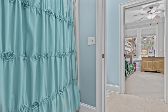 bathroom with ceiling fan, baseboards, crown molding, and tile patterned floors