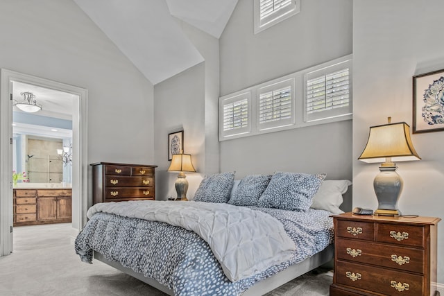 bedroom featuring carpet floors, ensuite bath, and high vaulted ceiling