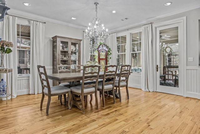 dining space with light wood finished floors, recessed lighting, visible vents, a decorative wall, and ornamental molding