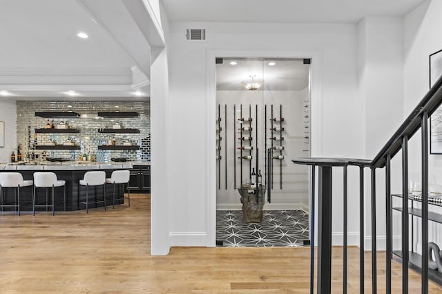 wine room featuring hardwood / wood-style flooring and indoor bar