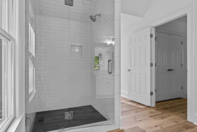 bathroom featuring hardwood / wood-style flooring and a shower with door