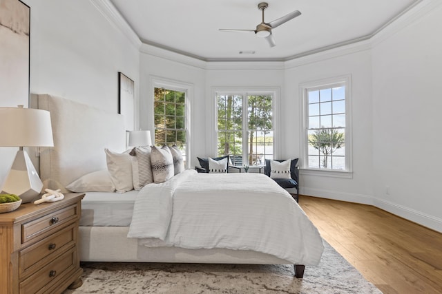 bedroom featuring ceiling fan, light hardwood / wood-style flooring, and crown molding