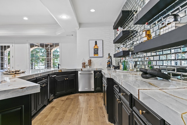 kitchen with light hardwood / wood-style flooring, sink, a tray ceiling, light stone countertops, and ornamental molding