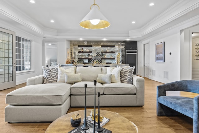 living room with light wood-type flooring, crown molding, and french doors