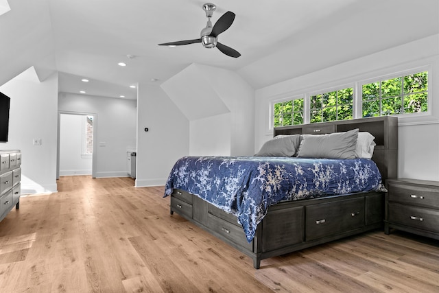 bedroom with ceiling fan, vaulted ceiling, and light hardwood / wood-style floors