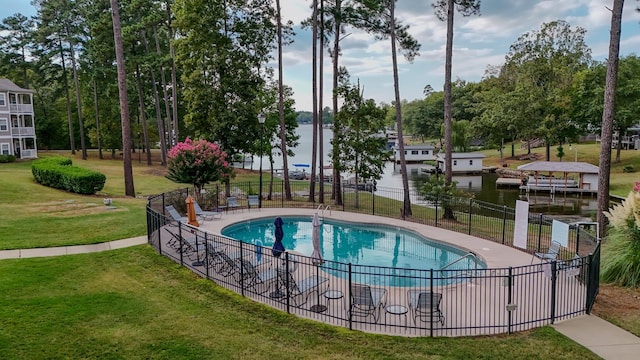 view of pool with a water view and a lawn