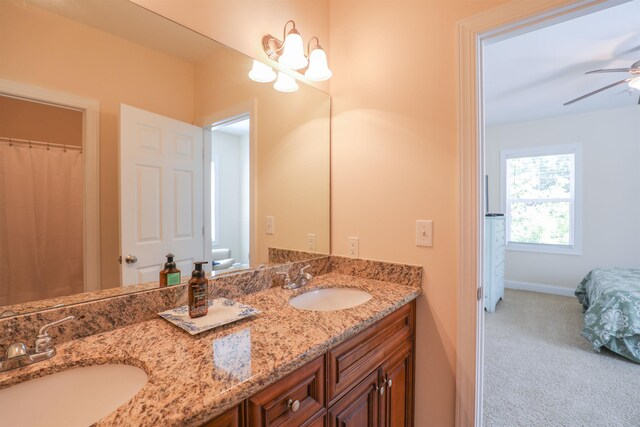 bathroom with vanity, toilet, and ceiling fan with notable chandelier