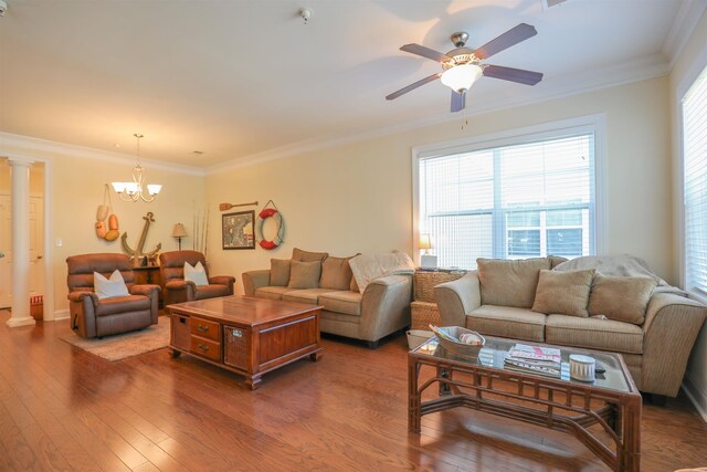 living room with dark hardwood / wood-style flooring, ceiling fan with notable chandelier, ornamental molding, and ornate columns