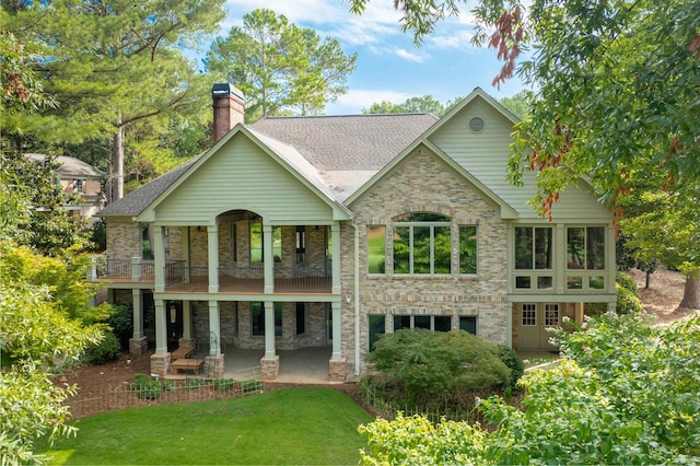 rear view of house featuring a patio area, a yard, and a balcony