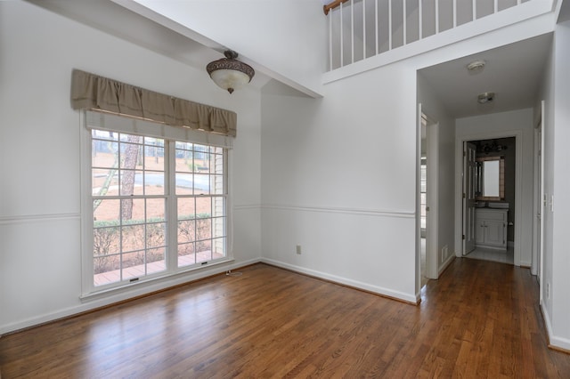 unfurnished room featuring dark wood finished floors and baseboards