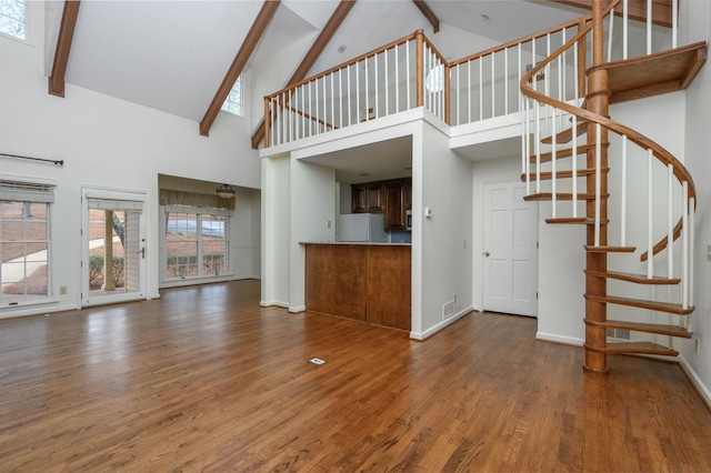 unfurnished living room with stairway, wood finished floors, and baseboards