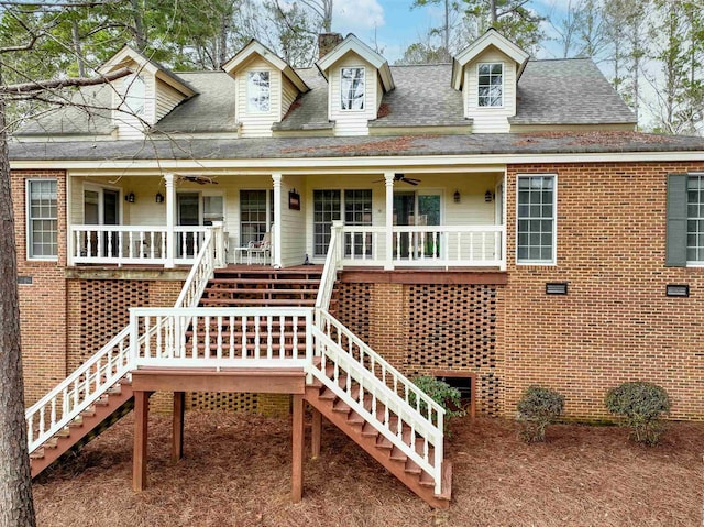 view of front of property featuring roof with shingles, stairs, a porch, and brick siding