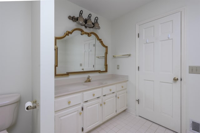 bathroom with toilet, vanity, visible vents, and tile patterned floors