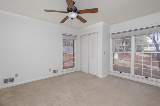 unfurnished bedroom featuring a closet, visible vents, light carpet, and baseboards