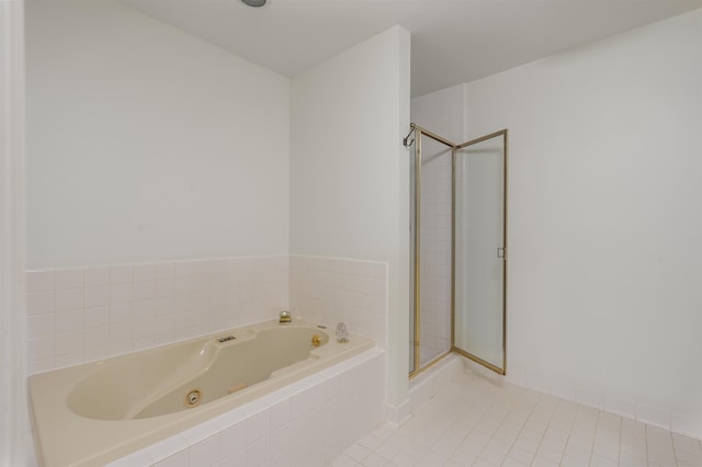 bathroom with a jetted tub, a shower stall, and tile patterned floors