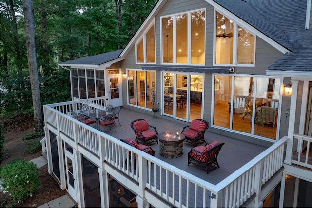 261 Reynolds Dr, Eatonton, GA 31024 - rear view of property featuring an outdoor fire pit, a shingled roof, a sunroom, and a deck
