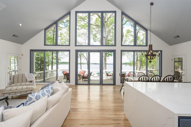 261 Reynolds Dr, Eatonton, GA 31024 - living area with high vaulted ceiling, a water view, and light wood-style floors