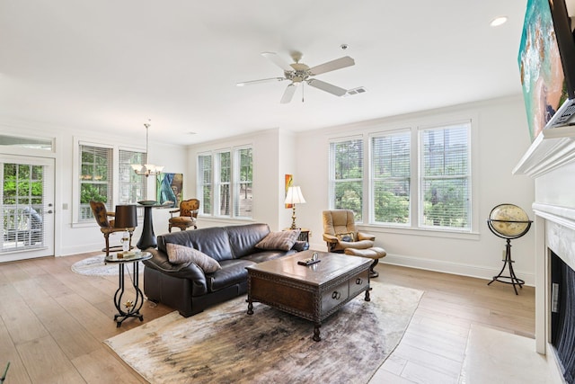 1010A Creekside, Greensboro, GA 30642 - living area featuring a premium fireplace, a chandelier, light wood-type flooring, ceiling fan, and baseboards