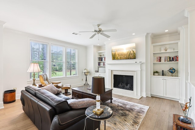 1010A Creekside, Greensboro, GA 30642 - living room with ceiling fan, light wood-style floors, a fireplace, built in shelves, and ornamental molding