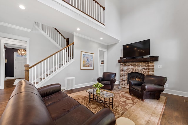855 Jasper St, Madison, GA 30650 - living room featuring crown molding, wood finished floors, stairway, a brick fireplace, and a high ceiling
