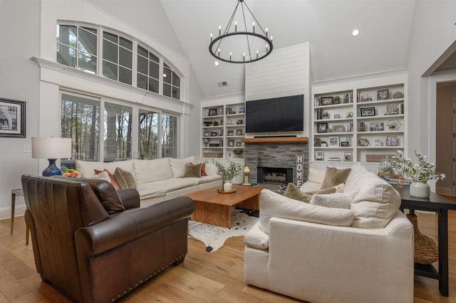 living area featuring high vaulted ceiling, hardwood / wood-style flooring, built in features, a fireplace, and a chandelier