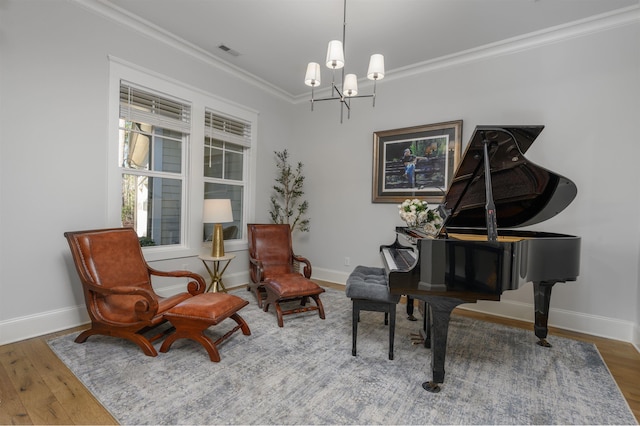 sitting room featuring wood finished floors, baseboards, visible vents, ornamental molding, and a notable chandelier