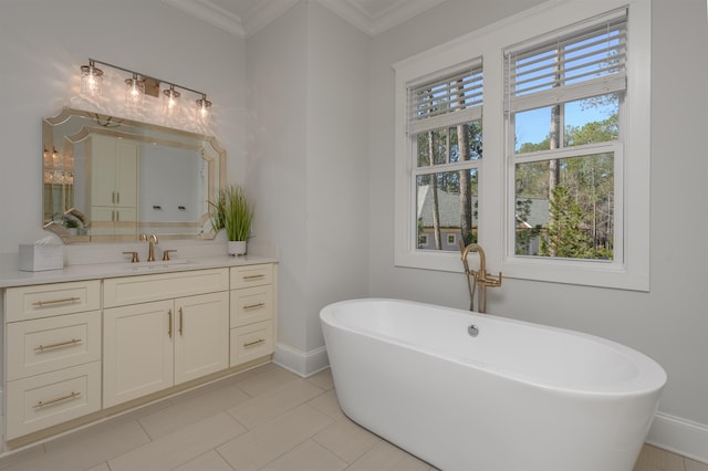 bathroom featuring baseboards, a freestanding bath, vanity, and crown molding