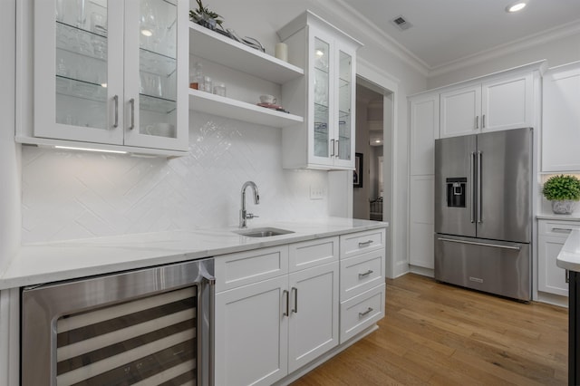 kitchen with visible vents, ornamental molding, a sink, wine cooler, and high quality fridge