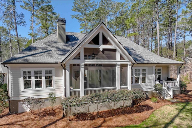 back of property with a ceiling fan, a sunroom, a shingled roof, a chimney, and crawl space