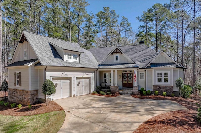 view of front of house with a standing seam roof, a porch, french doors, stone siding, and board and batten siding