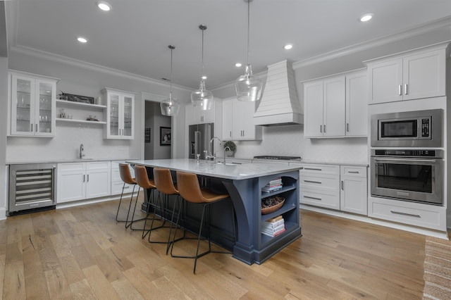 kitchen with premium range hood, open shelves, ornamental molding, stainless steel appliances, and wine cooler