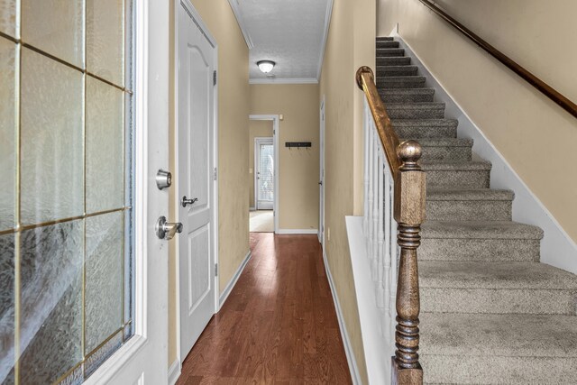 interior space featuring crown molding, wood-type flooring, and a textured ceiling