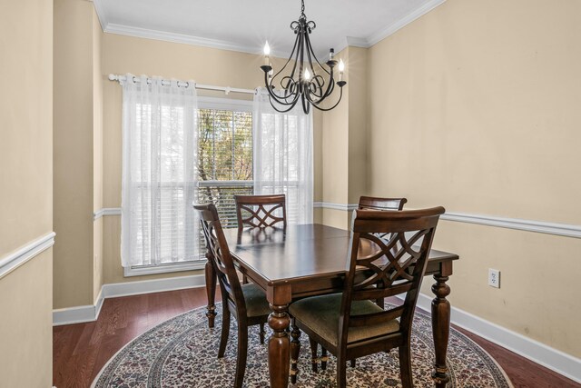 dining room with a notable chandelier, ornamental molding, and dark hardwood / wood-style floors